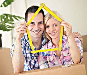 Immobilien-Rechtsschutz: Paar mit Umzugskartons und Zollstock